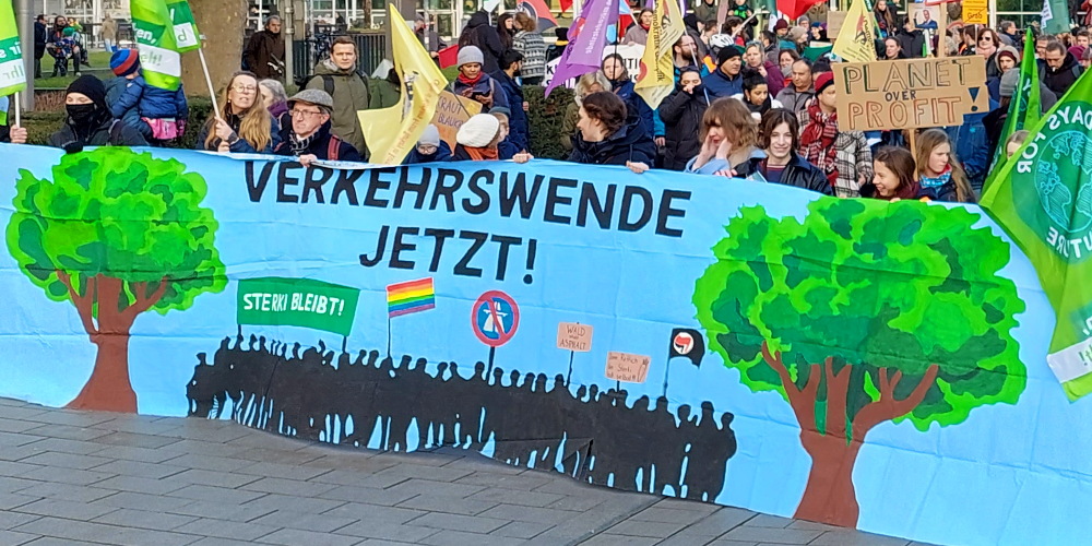 Die Spitze eines Demonstrationszuges mit einem Banner, auf dem "Verkehrswende jetzt!" steht