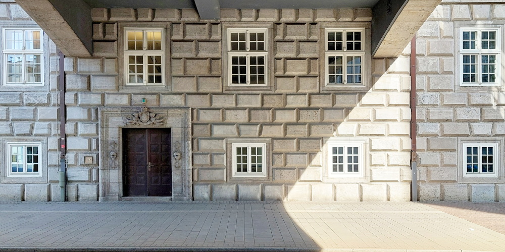 Historische Fassade mit einer Holztür und mehreren Fenstern